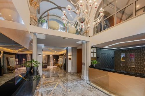 a lobby with a chandelier in a building at Hotel Museum Budapest in Budapest