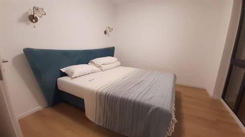 AURORA suites في Ghiroda: سرير صغير ومخدتين عليه في غرفة