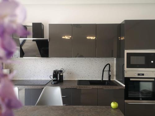 a kitchen with a sink and a microwave at AURORA suites in Ghiroda