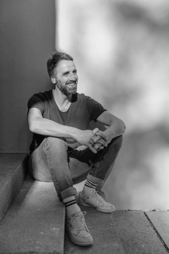 a man sitting on the step of a building at Blyb Hotel in Gmund am Tegernsee