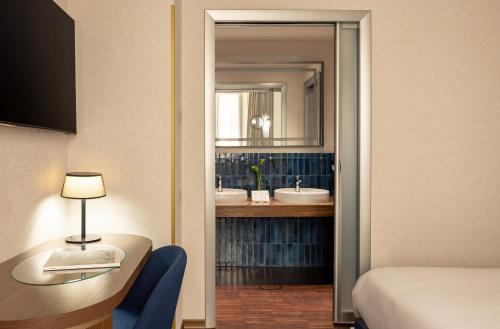 a hotel room with a bathroom with two sinks at Maison Roma Piazza di Spagna UNA Esperienze in Rome