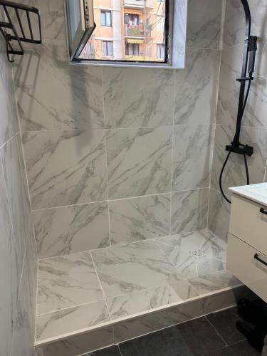 a bathroom with a marble shower with a window at Location de chambre privée dans résidence privée,parking gratuit , 1 minute du tramway, à 9 minute du centre ville, accessible à plusieurs transports in Nice
