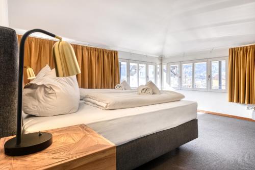 1 dormitorio con 1 cama grande y 1 lámpara en Familienferienwohnung HEIMat en Bludenz