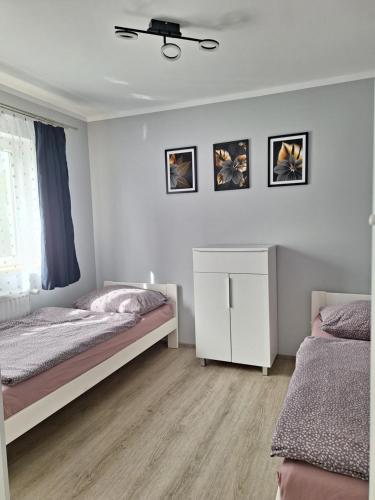 1 dormitorio con 2 camas y armario blanco en Noclegi Różanka, en Radomierz