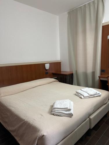 1 dormitorio con 1 cama con 2 toallas en Locanda Agnello en Taino