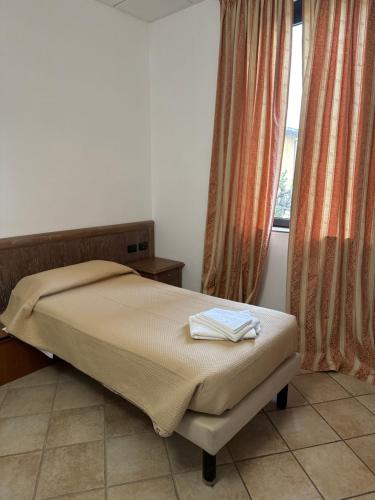 1 dormitorio con cama y ventana en Locanda Agnello en Taino