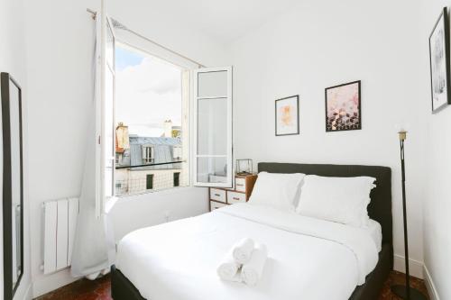 Un dormitorio con una gran cama blanca y una ventana en Central Paris - Sentier - CityApartmentStay en París