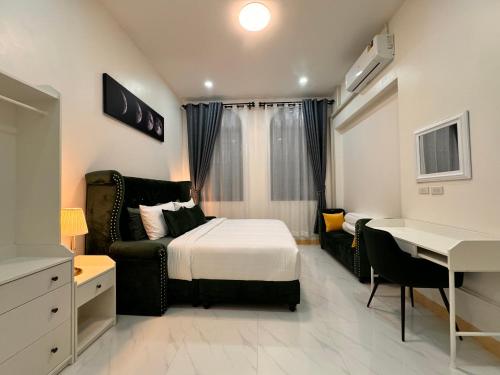 1 dormitorio con cama, escritorio y mesa en Le Trang Boutique Airport, en Trang