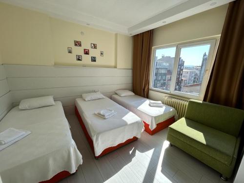 a room with two beds and a chair and a window at NAVAL HOTEL YALOVA in Yalova