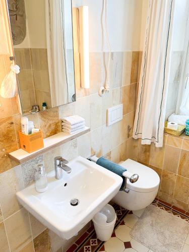 ein Badezimmer mit einem Waschbecken, einem WC und einem Spiegel in der Unterkunft Lehnervilla in Parsberg