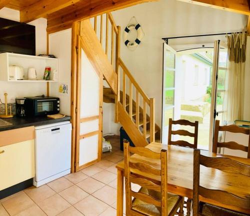une cuisine avec une table et un escalier dans une maison dans l'établissement La Grange Dimière - Duplex 3 pers - Parking privé, à Saint-Martin-Boulogne
