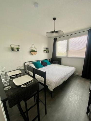 - une chambre avec 2 lits et une table avec une table sidx sidx dans l'établissement Appartement Royan centre-ville, à Royan