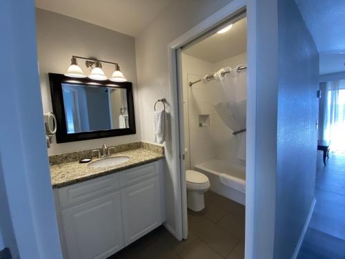 a bathroom with a sink and a toilet and a mirror at WorldMark Havasu Dunes in Lake Havasu City