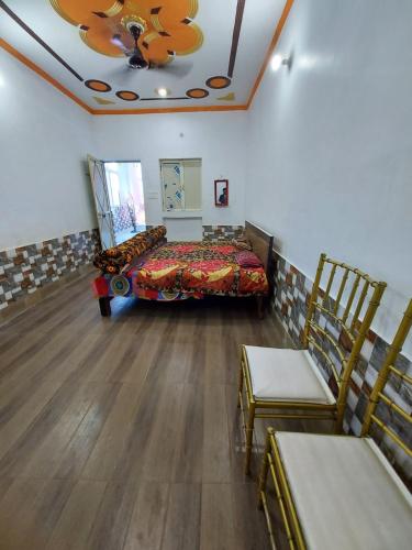 um quarto com uma cama e duas cadeiras em Sanjay resort and hotel em Bareilly