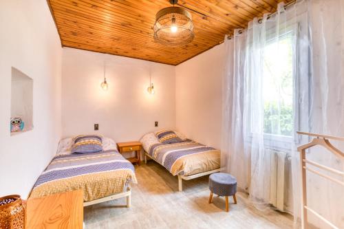 two beds in a room with a window at Maison de Campagne in Gignac