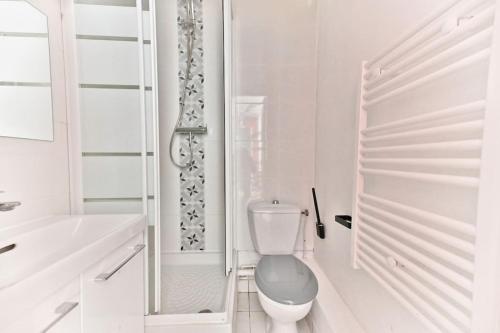 une salle de bain blanche avec toilettes et baignoire dans l'établissement Charmant Studio dans le centre de Paris, à Paris