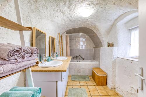 a bathroom with two sinks and a tub at Maison de Campagne in Gignac