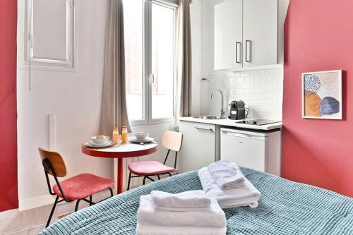 Cette chambre comprend un lit, une table et une cuisine. dans l'établissement Charmant Studio dans le centre de Paris, à Paris