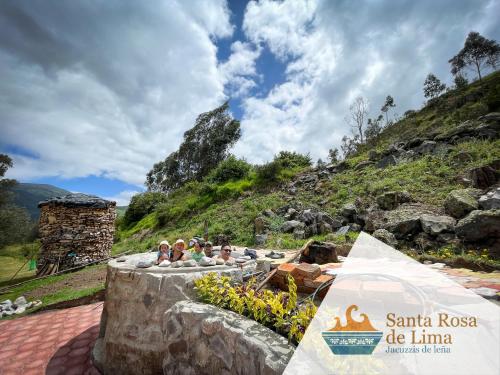 un grupo de personas sentadas sobre una pared de piedra en Santa Rosa de Lima Hostal Zuleta, en Hacienda Zuleta