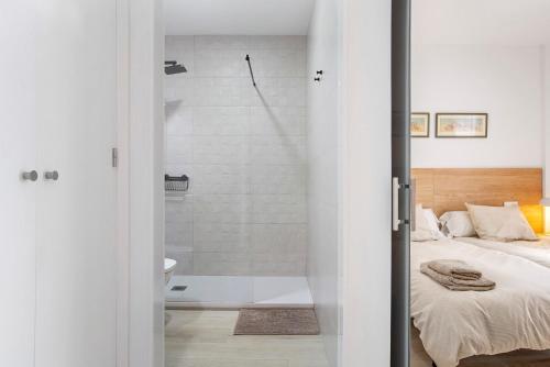 a bedroom with a shower and a bed and a tub at Apartamento María Conil Bajo in Conil de la Frontera