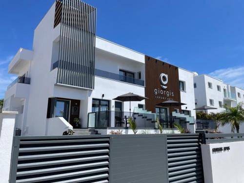 a white building with a sign in front of it at Giorgis Luxury Apartments in Ayia Napa