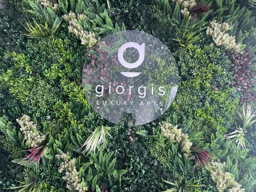 a sign for a garden with flowers and plants at Giorgis Luxury Apartments in Ayia Napa