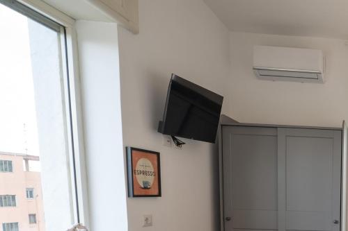 een flatscreen-tv aan de muur van een kamer bij Seconda Stella a Destra in Napels