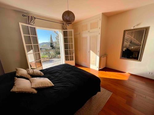 1 dormitorio con 1 cama grande y ventana grande en Villa à flanc de colline en Saint-Ambroix