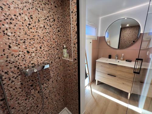 uma casa de banho com um chuveiro, um lavatório e um espelho. em Paisible gîte moderne avec vue sur le Luberon em La Motte-dʼAigues