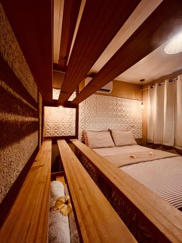 two beds in a room with wooden floors at Martinelli Residence in Fernando de Noronha