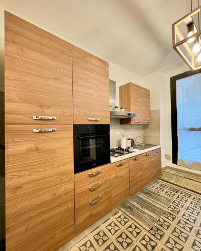 a kitchen with wooden cabinets and a black microwave at Giulivi Assisi Apartments in Assisi