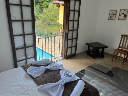 a bedroom with a bed and a view of a pool at Pousada dos Girassóis in Conservatória