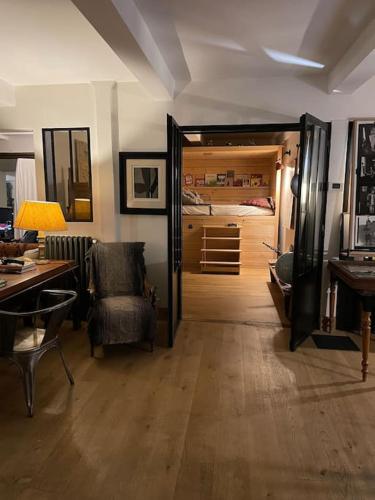 a living room with a desk and a bedroom at Très beau Loft Industriel Paris 20e in Paris