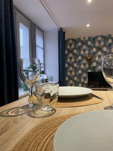 - une table avec deux verres à vin et une assiette dans l'établissement L’azur au centre de Vitré et proche château/gare, à Vitré