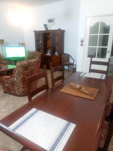 sala de estar con mesa de madera y sillas en NLD Ngallele 2, en Ngalel