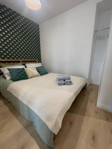 une chambre avec un lit avec deux serviettes dessus dans l'établissement L’azur au centre de Vitré et proche château/gare, à Vitré