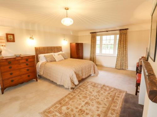 a bedroom with a bed and a dresser and a window at Moon Field Lodge in Scunthorpe