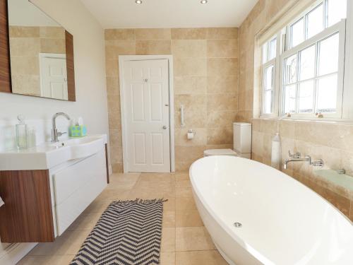 a bathroom with a tub and a sink and a toilet at Moon Field Lodge in Scunthorpe