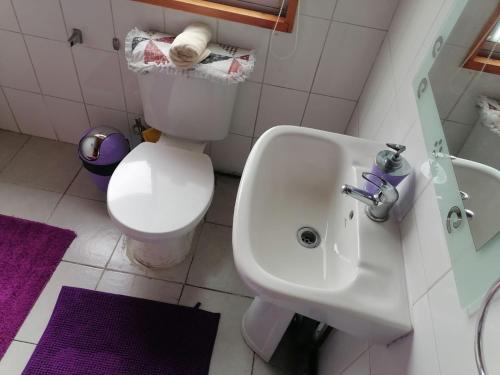 y baño con lavabo blanco y aseo. en Hospedaje Familiar Doña Juanita, en Puerto Montt