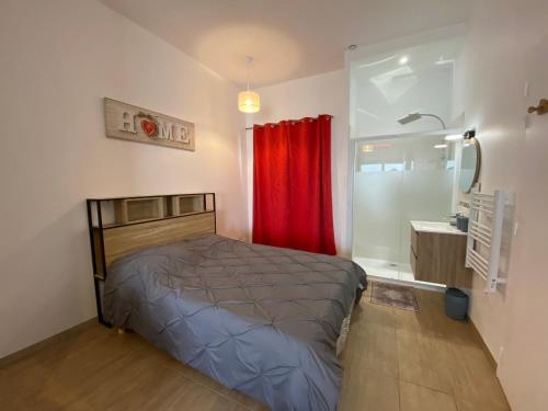 1 dormitorio con cama y cortina roja en Chez Claire et Ju, en Égly