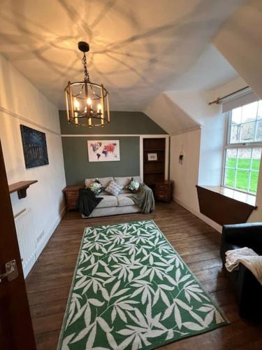 a living room with a couch and a green and white rug at The Mews Holiday Let in Tillicoultry