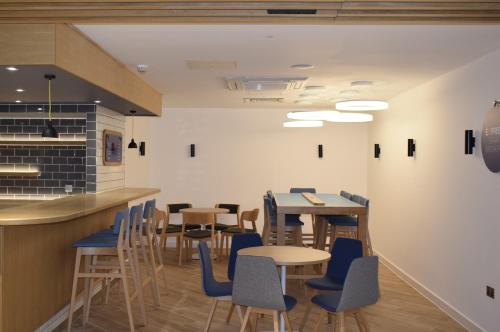 a restaurant with tables and chairs and a counter at Holiday Inn Express London Croydon by IHG in Croydon