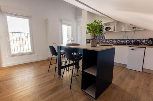 une cuisine avec une table et des chaises dans une pièce dans l'établissement Appartement neuf climatisé tout équipé 2 à 4 couchages, à Béziers