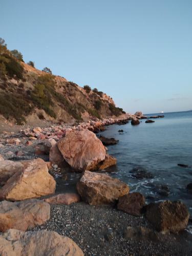 a group of rocks on a beach near the water at Forever Blue in Salamís