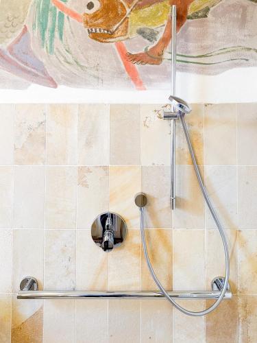 eine Dusche mit einem Schlauch an einer gefliesten Wand in der Unterkunft Lehnervilla in Parsberg