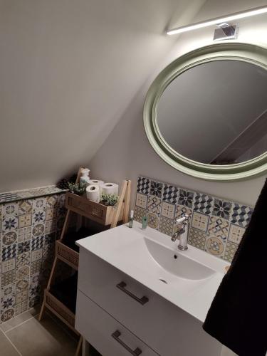 a bathroom with a sink and a large mirror at Appartement Terrasse in Bagnoles de l'Orne