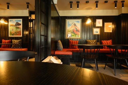 a restaurant with tables and chairs and paintings on the walls at Tyn-y-Coed Inn in Betws-y-coed
