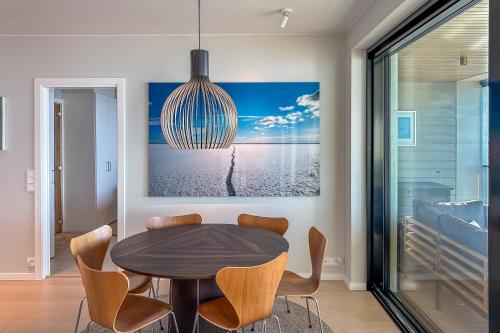 a dining room with a table and a chandelier at Hanko Kuningatarranta Apartment in Hanko