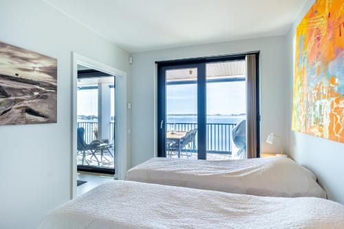 a bedroom with two beds and a view of the ocean at Hanko Kuningatarranta Apartment in Hanko