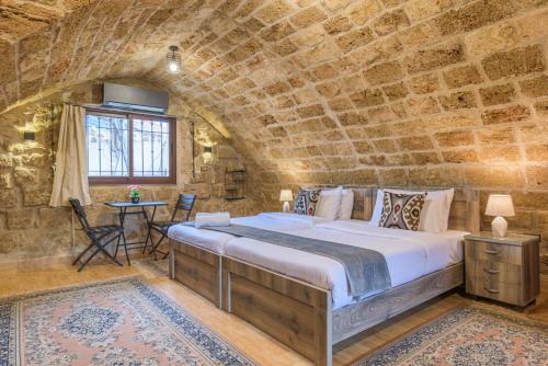 ein Schlafzimmer mit einem großen Bett in einer Steinmauer in der Unterkunft Timberwood Studio in Batroun in Batrun